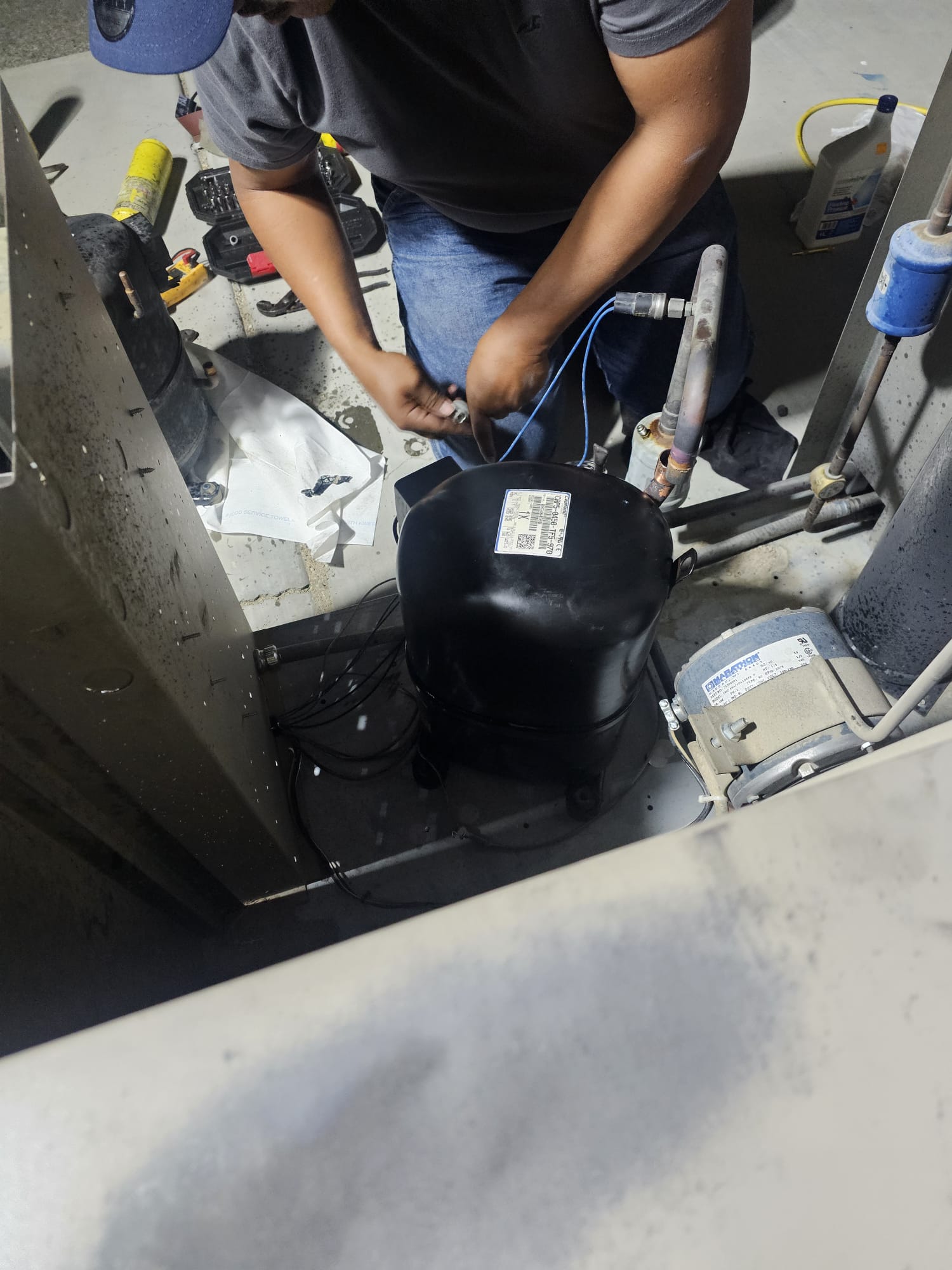 Técnico trabajando sobre un compresor de refrigeración
