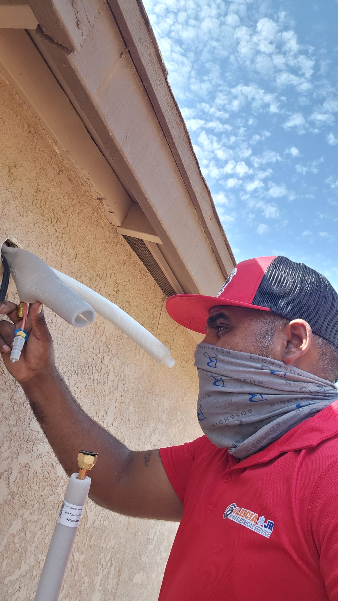Técnico colocando canalización exterior para líneas de refrigeración